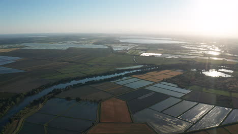 Luftaufnahme-Des-Sonnenuntergangs-über-Einem-Flussteich-Und-überfluteten-Reisfeldern-In-Der-Camargue,-Frankreich